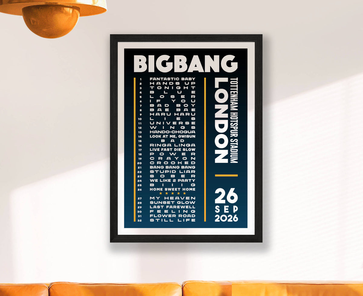 A framed BigBang gig setlist poster for London on 26 September 2026 hanging on a white wall above an orange sofa, with a warm light fixture visible in the top left corner.