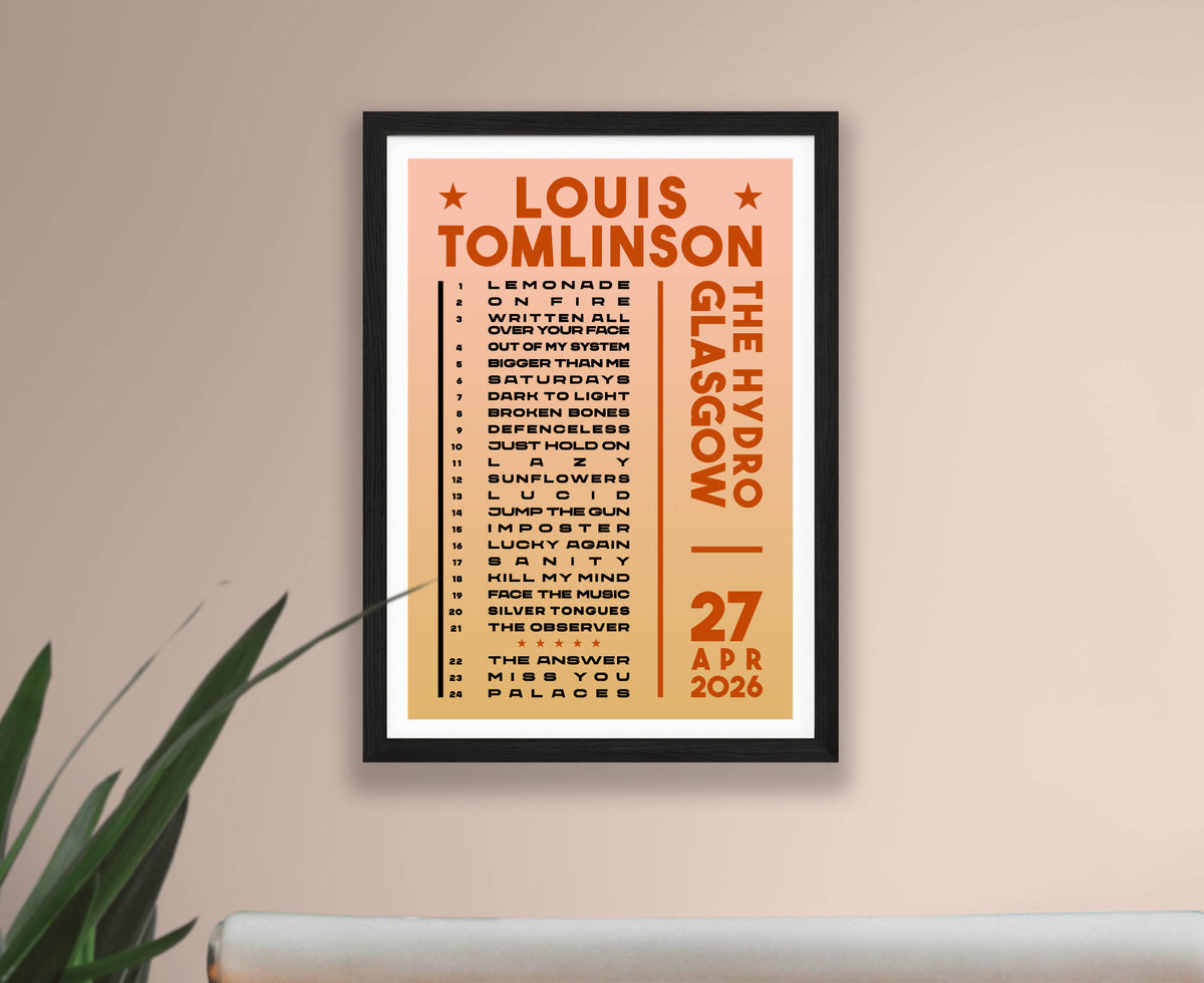 A framed Louis Tomlinson Glasgow gig setlist poster for 27 April 2026. Hanging on a beige wall above a white surface, with a green plant leaf visible on the left.