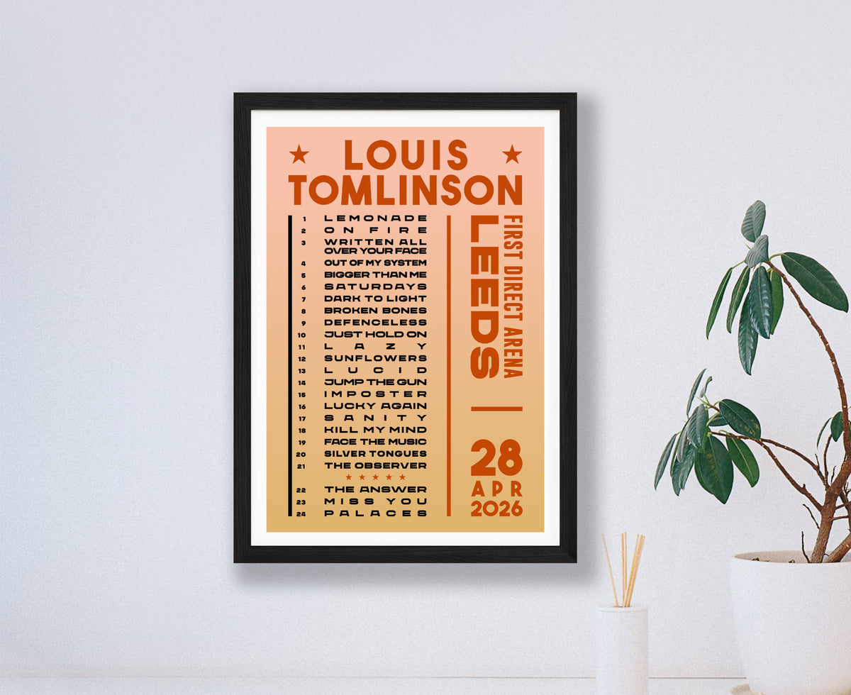 A Louis Tomlinson concert setlist poster for Leeds on 28 April 2026, shown in a black frame on a white wall with a plant in the corner below. 