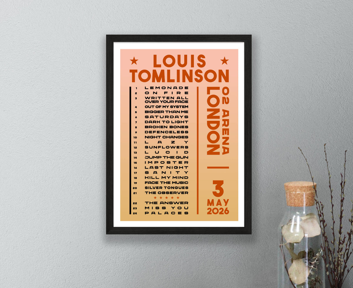A Louis Tomlinson London O2 Arena concert poster from 3 May 2026, displayed in a frame on a light gray wall next to a glass jar with dried stems.